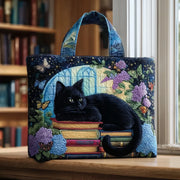 Handmade artisanal tote bag featuring a black cat sitting on a stack of books