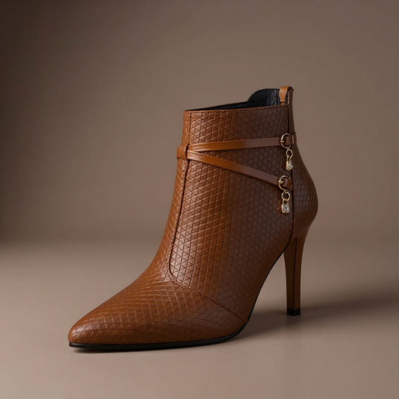 Faux leather stiletto heel boots with crossed straps, crystal charm accents and a pointed toe