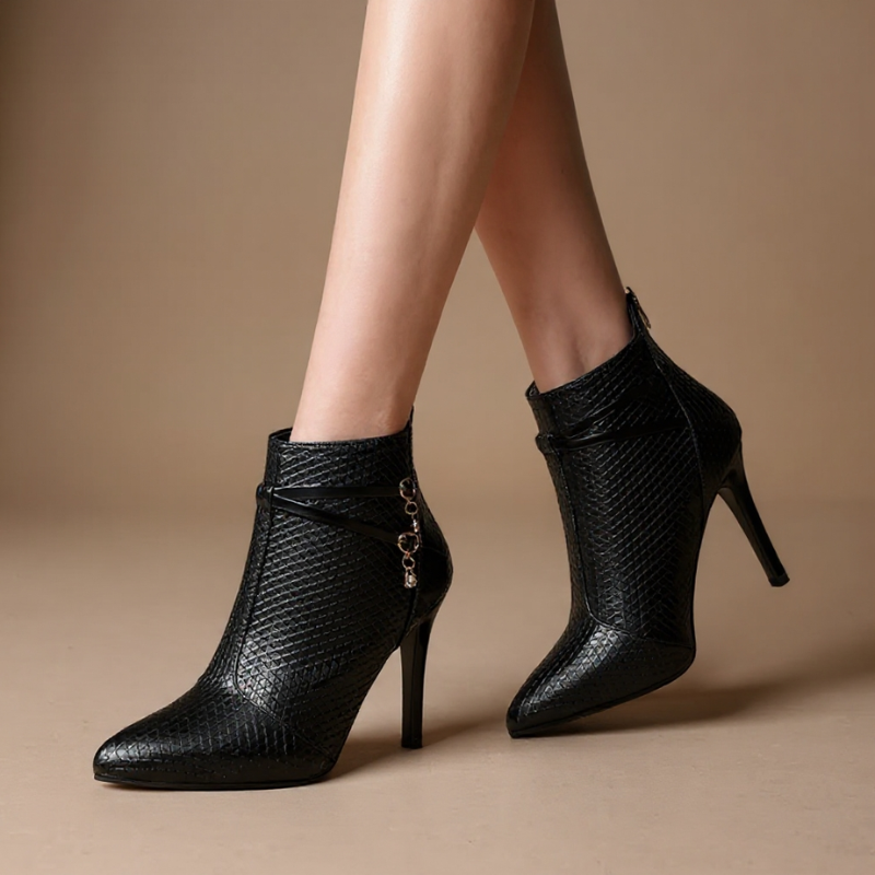 Faux leather stiletto heel boots with crossed straps, crystal charm accents and a pointed toe