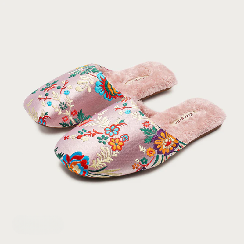 Satin floral slippers with embroidered detailing and soft plush lining, shown in green, pink and black