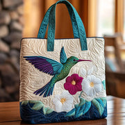 Quilted handmade bag with hummingbird and white flower design, shown in two sizes