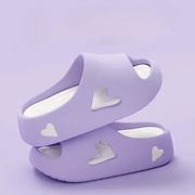 Heart-detail cushioned platform slides shown in purple, khaki, black and white