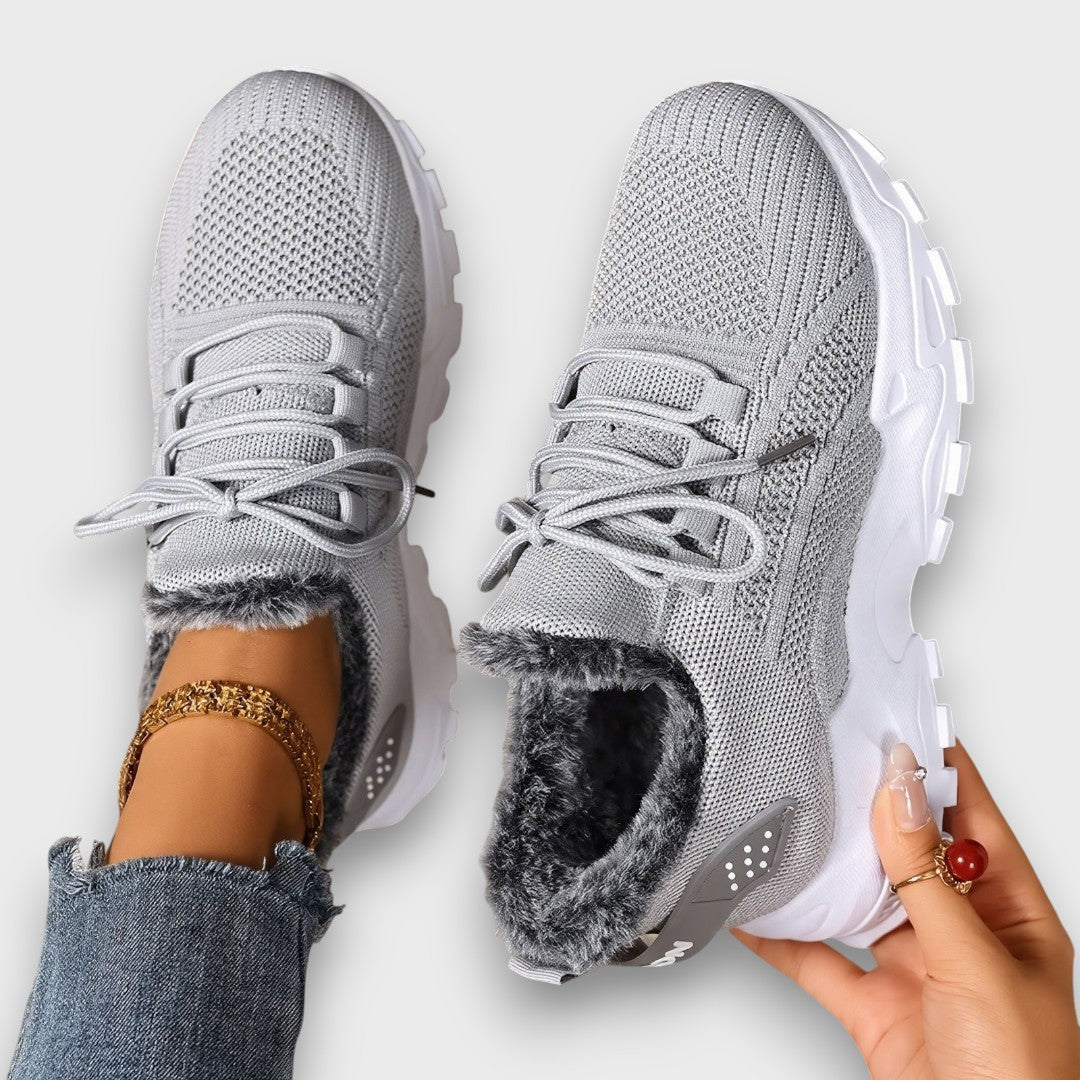 Lace-up insulated winter sneakers with a lightweight sole, shown in a casual everyday style