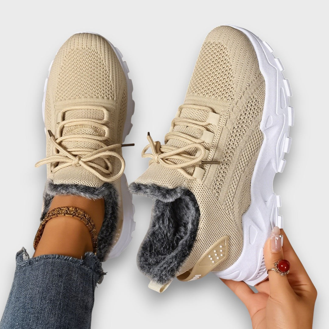 Lace-up insulated winter sneakers with a lightweight sole, shown in a casual everyday style