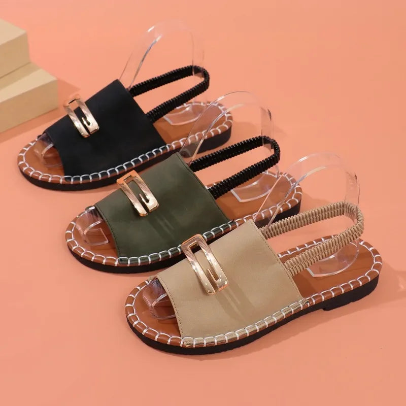 Flat sandals with gold buckle accent and contrast stitching in neutral tones