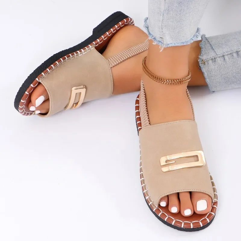 Flat sandals with gold buckle accent and contrast stitching in neutral tones