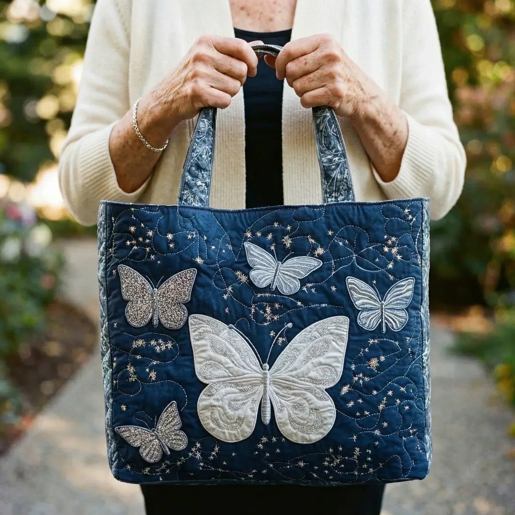 Handmade silver artisan bag with butterfly detail, shown in two sizes