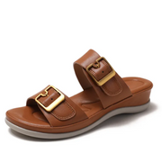 Women's cushioned double-strap slide slippers with gold-tone buckles in a neutral tone